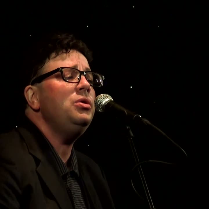 Close view of Tony Costello singing into a microphone
